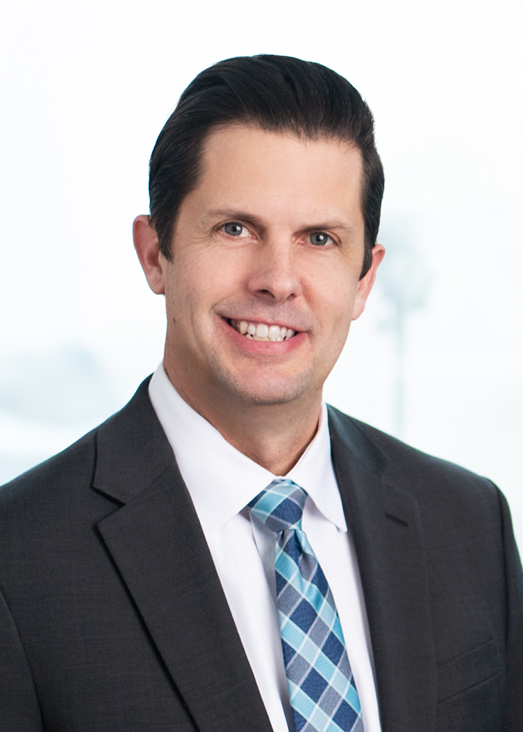 Professional headshot of Stephen Tobin with blurred background