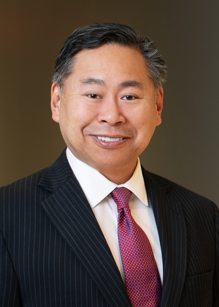 Professional photo of Shanlon Wu in a suit standing in an office