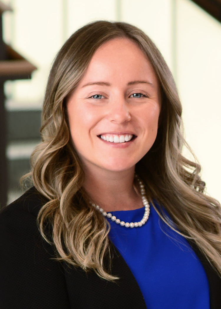 Aislinn Sroczynski close up headshot in black blazer and blue top